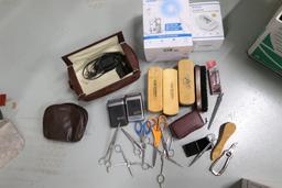 Shoe polishing brushes, scissors, vintage electric razors, and a Waterpik flosser, new in box