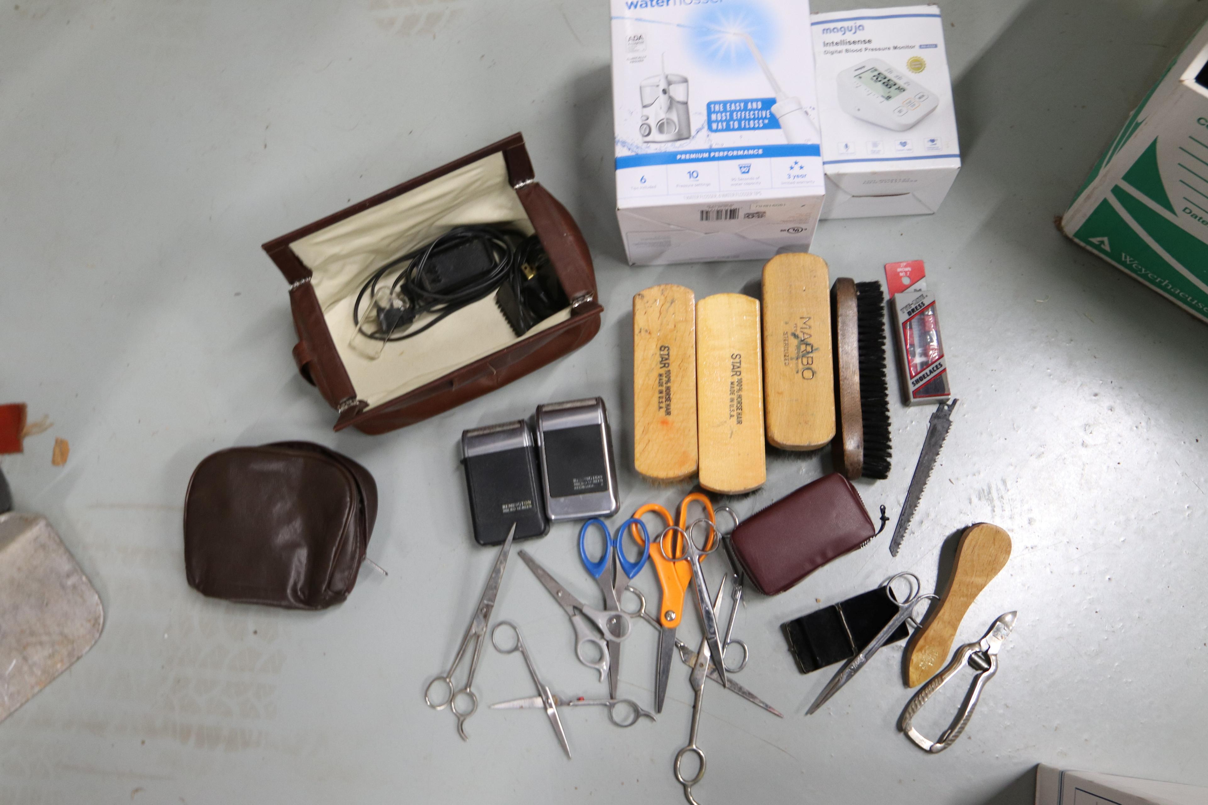 Shoe polishing brushes, scissors, vintage electric razors, and a Waterpik flosser, new in box