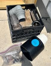Sewer fittings & wood pieces in milk crate