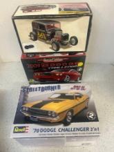 two Dodge Challenger and one Ford Victoria, car models in open boxes
