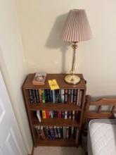 Bookshelf with books, lamp and wall mirror