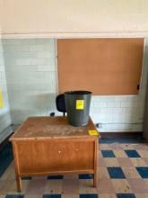Wood teachers desk with bin and office chair, cork board, room 1509