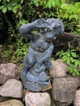 Boy riding fish lawn fountain