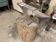 Anvil mounted on log.