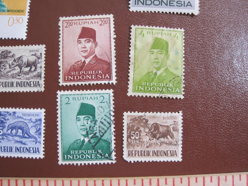 Lot of colorful Indonesia postage stamps, many of them unused