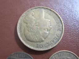 Three French coins: one 1923 50 centimes, one 1951 10 francs and one 1953 50 francs