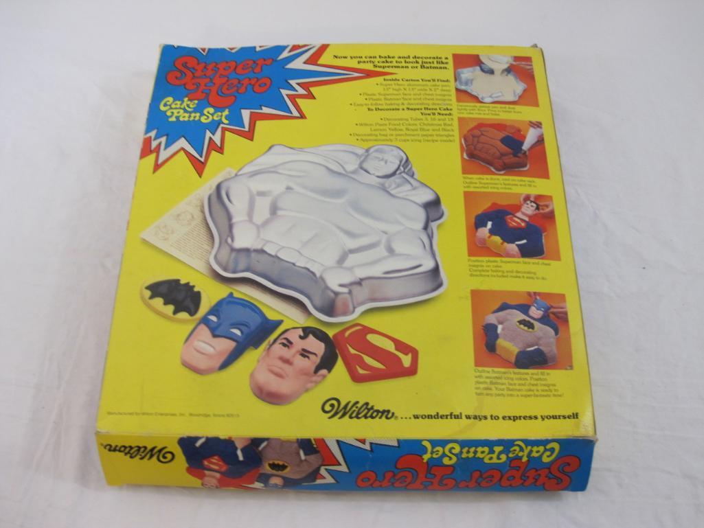 Wilton Super Hero Cake Pan Set, includes cake pan and plastic faces and shields for Batman and