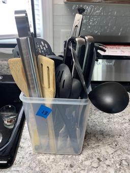 Container full of serving tongs spatula?s soup ladles pasta spoons plus