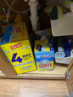 Cabinet full of trash bags dishwasher tablets cleaning supplies