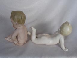 Two bisque Piano Babies:- Seated 13cm brown molded hair, painted features,