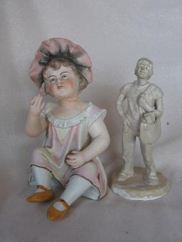 Three Figurines:- Bisque Heubach type 15cm seated boy with crossed legs inc