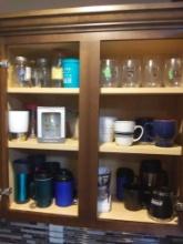 Cabinet full of glass, ceramic, and resin kitchen cups including coffee and insulated mugs