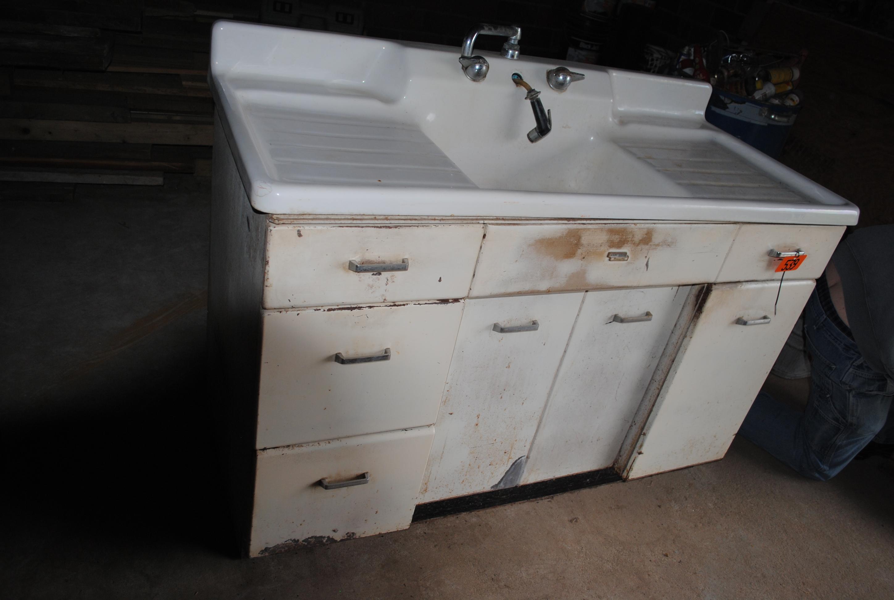 White porcelain sink & steel wheel encased in wood frame