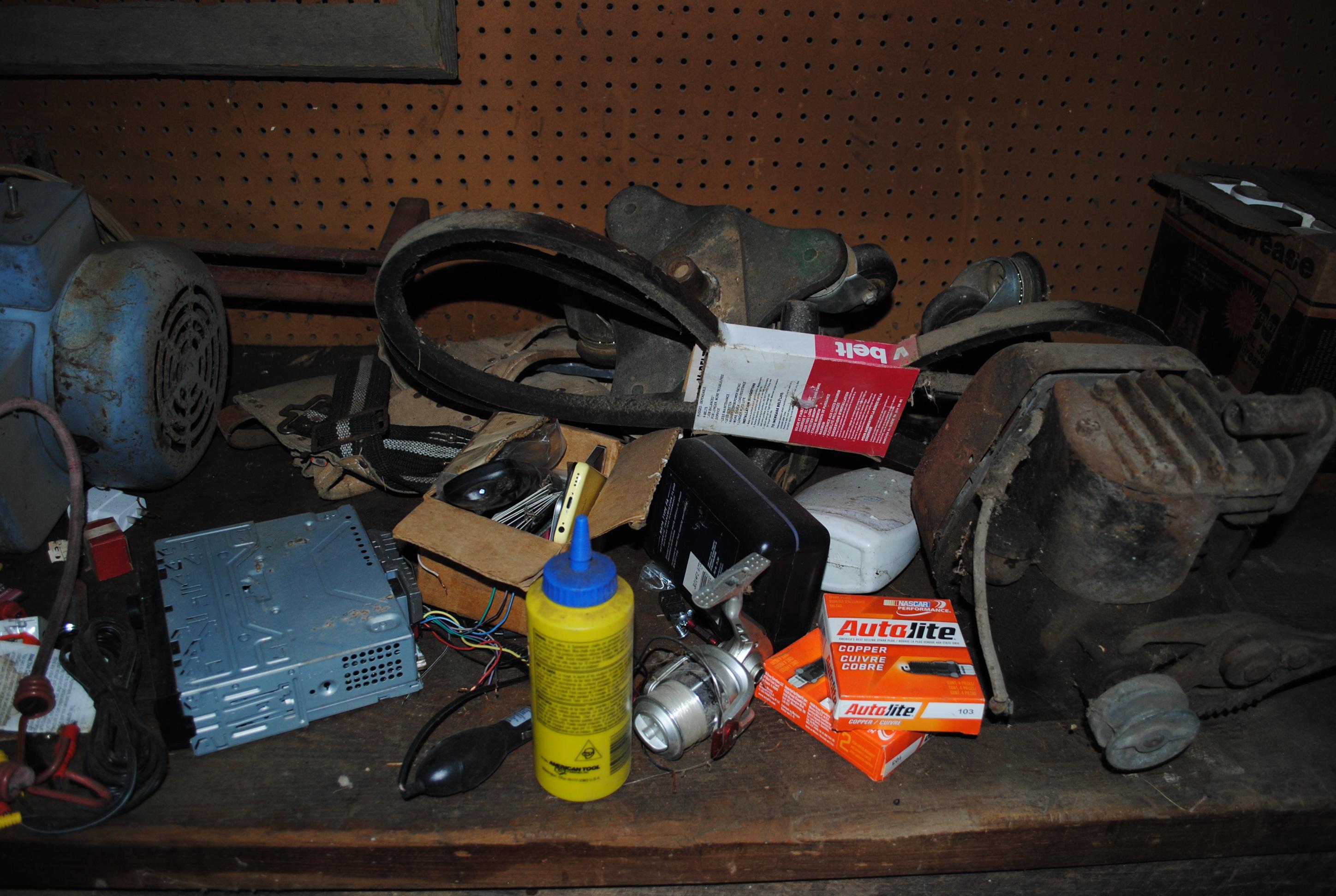 Contents on top of wood work bench including kick-start engine, compressor pump, Massey Ferguson v-b