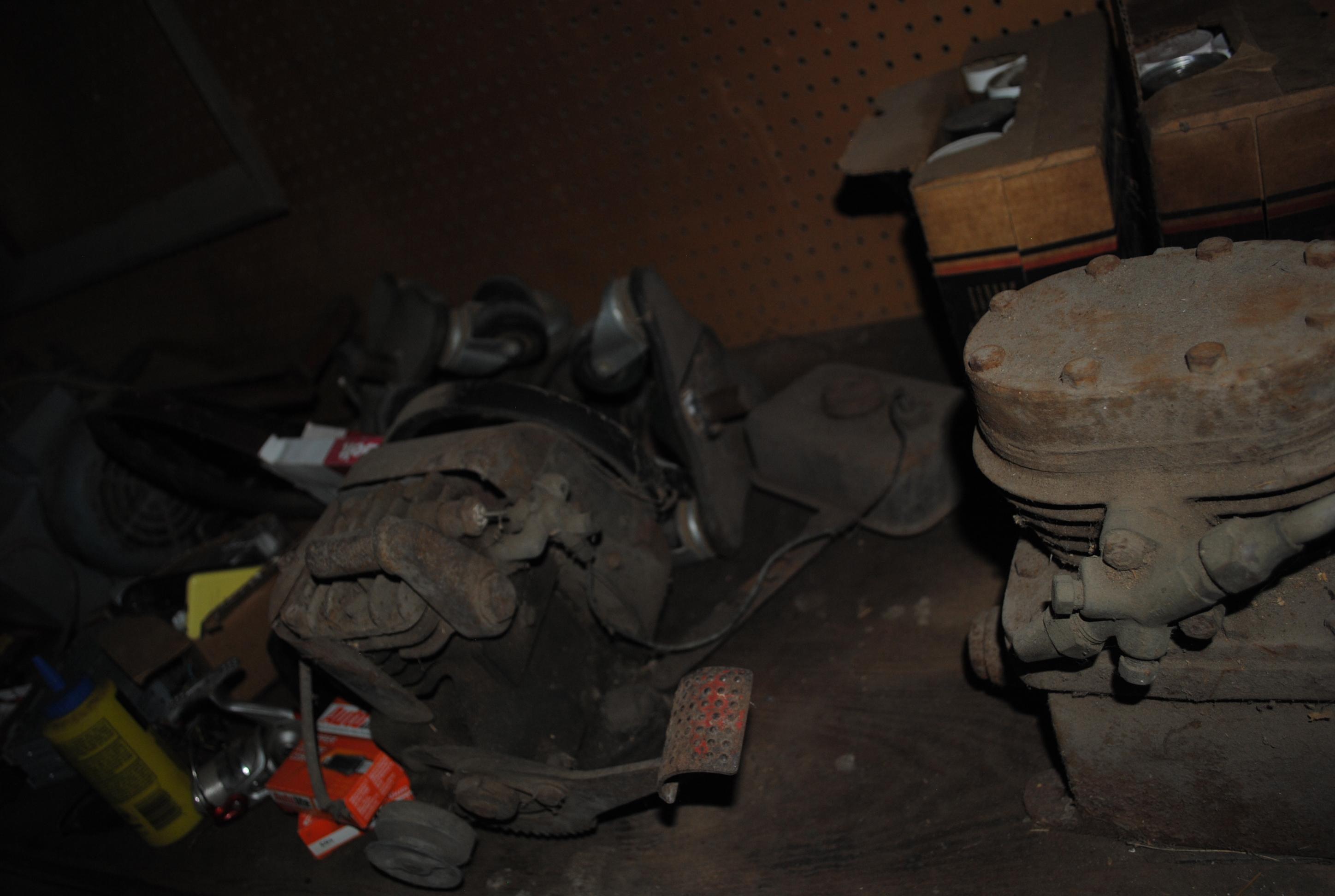 Contents on top of wood work bench including kick-start engine, compressor pump, Massey Ferguson v-b