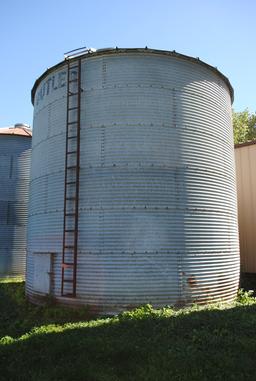 Butler 7-ring grain bin, approx. 18' high and 18' wide, has side ladder. The bottom ring is half bur