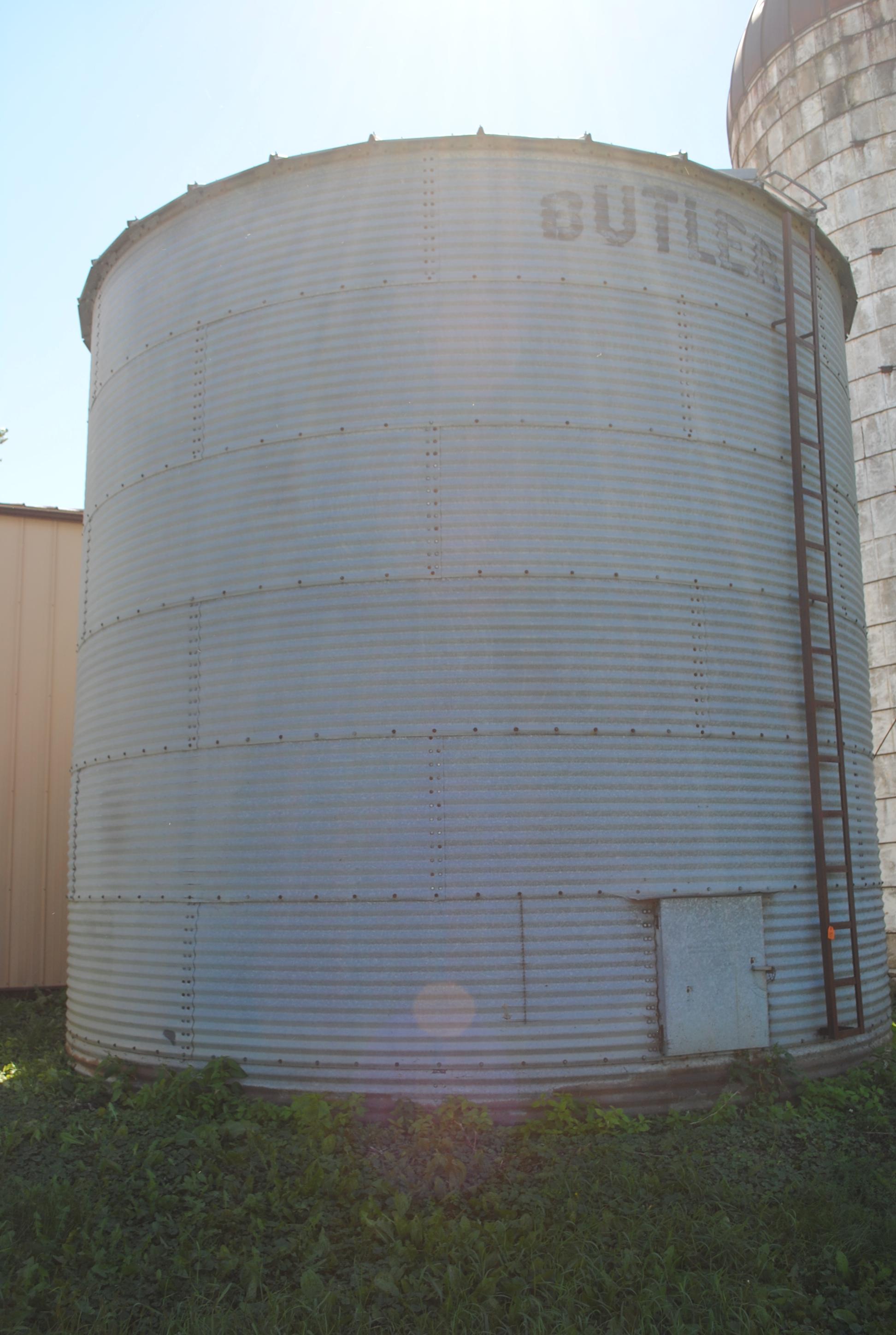 Butler 7-ring grain bin, approx. 18' high and 18' wide, has side ladder. The bottom ring is half bur