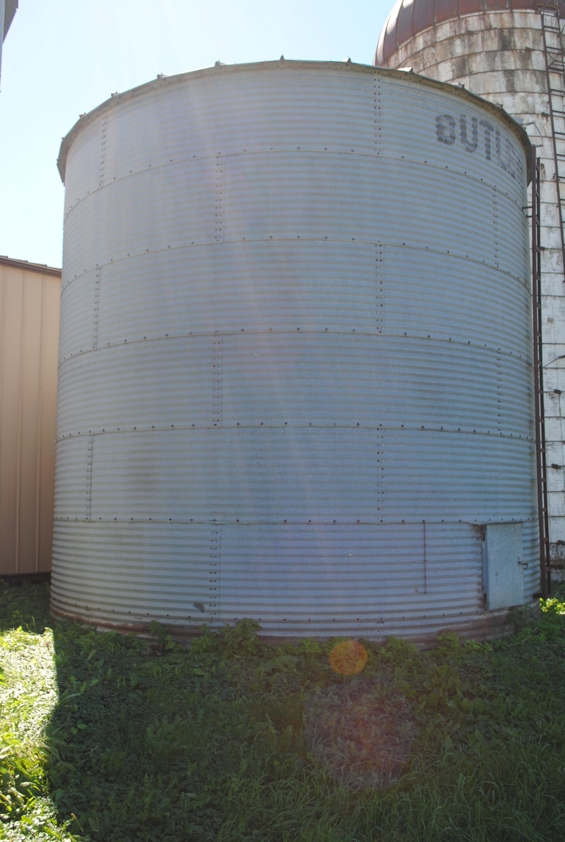 Butler 7-ring grain bin, approx. 18' high and 18' wide, has side ladder. The bottom ring is half bur