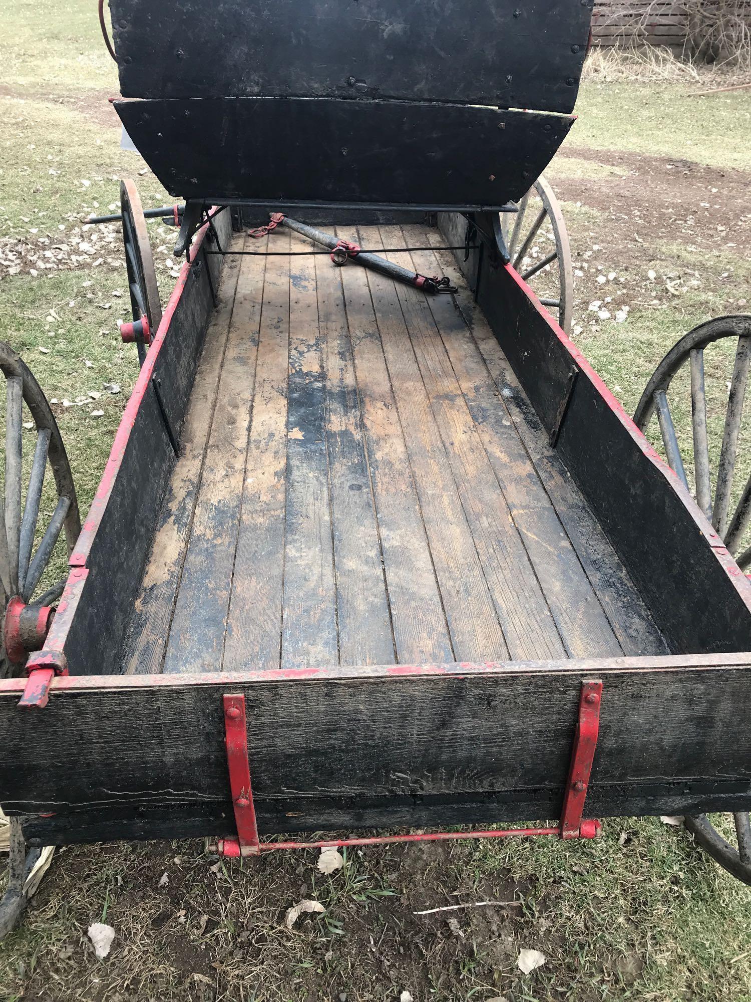 Two horse buck board with 2 person wood seat on wood spoke wheels. Box is 35"W x 8' 8"L. Rear wheels