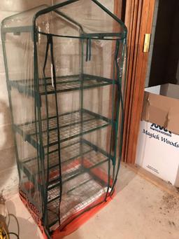 Miniature greenhouse with four shelves and plastic cover. No shipping.