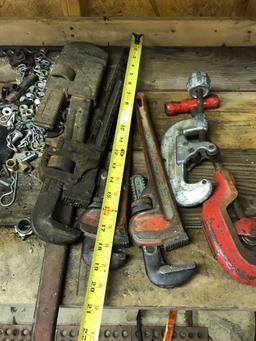 Lot of pipe wrenches and pipe cutters