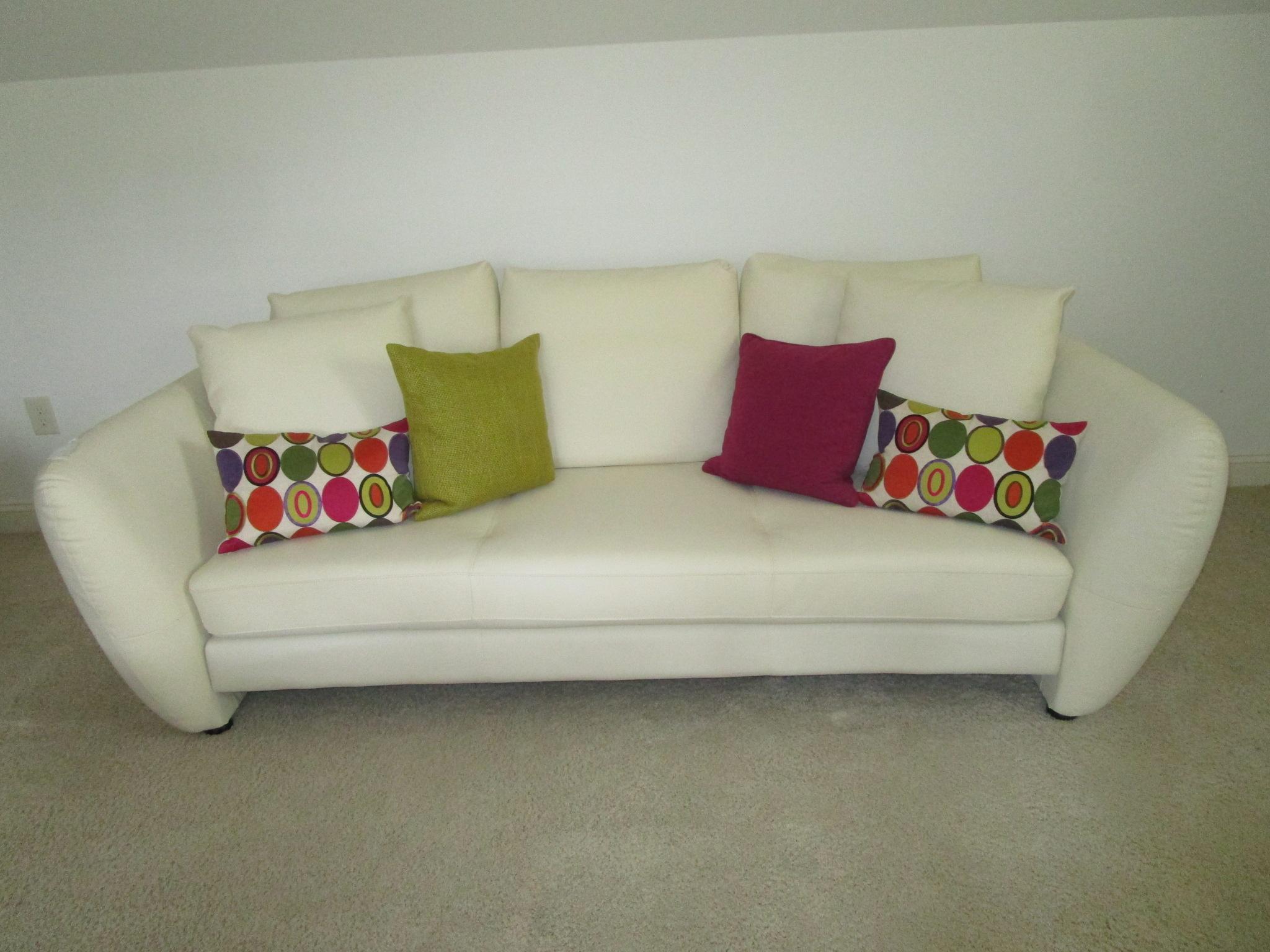 Beautiful White Leather Sofa w/Bright Cloth Covered Accent Pillows.