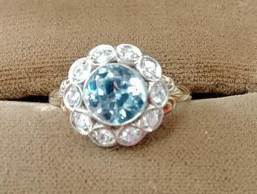 10 kt, y/g ring with 12.5mm round blue topaz, with ten (10) .01 spinels. Total weight 2.98 gms. Size