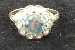 10 kt, y/g ring with 12.5mm round blue topaz, with ten (10) .01 spinels. Total weight 2.98 gms. Size