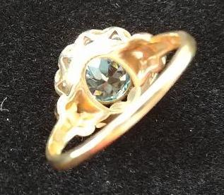 10 kt, y/g ring with 12.5mm round blue topaz, with ten (10) .01 spinels. Total weight 2.98 gms. Size