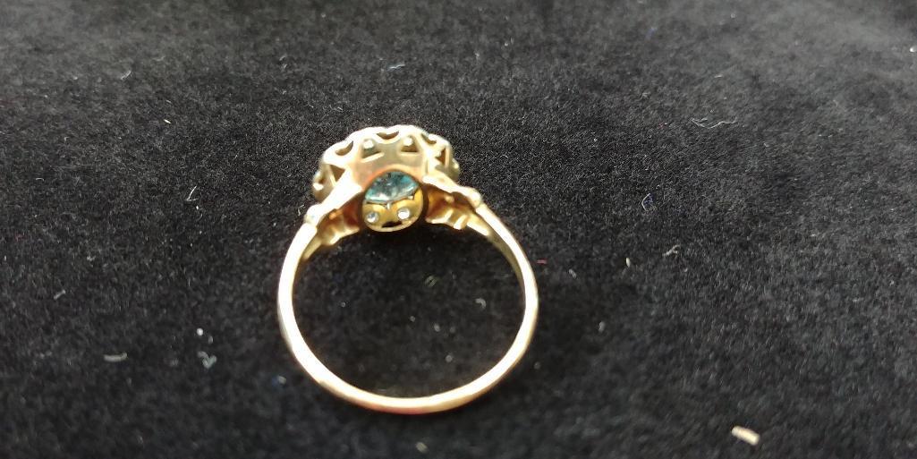 10 kt, y/g ring with 12.5mm round blue topaz, with ten (10) .01 spinels. Total weight 2.98 gms. Size