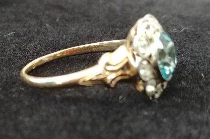 10 kt, y/g ring with 12.5mm round blue topaz, with ten (10) .01 spinels. Total weight 2.98 gms. Size