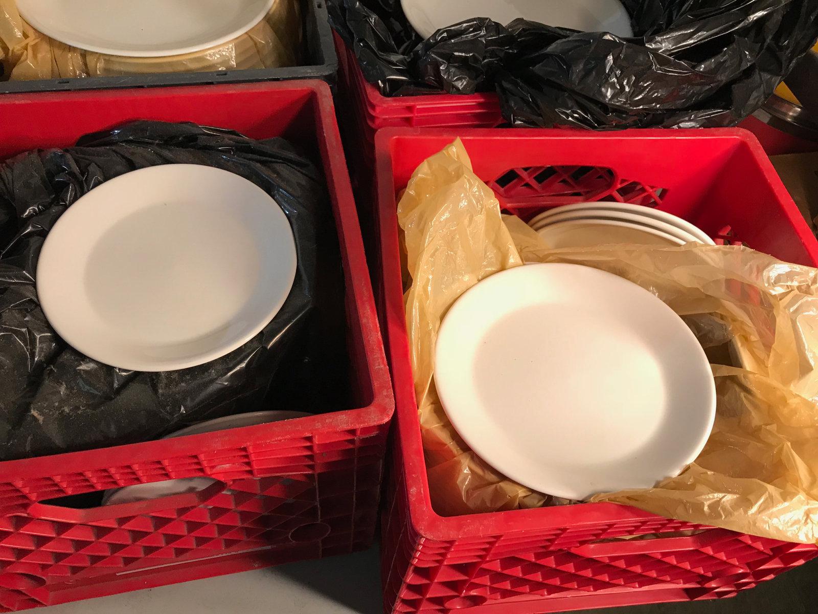 6 milk crates with various dishes, mostly dinner plates