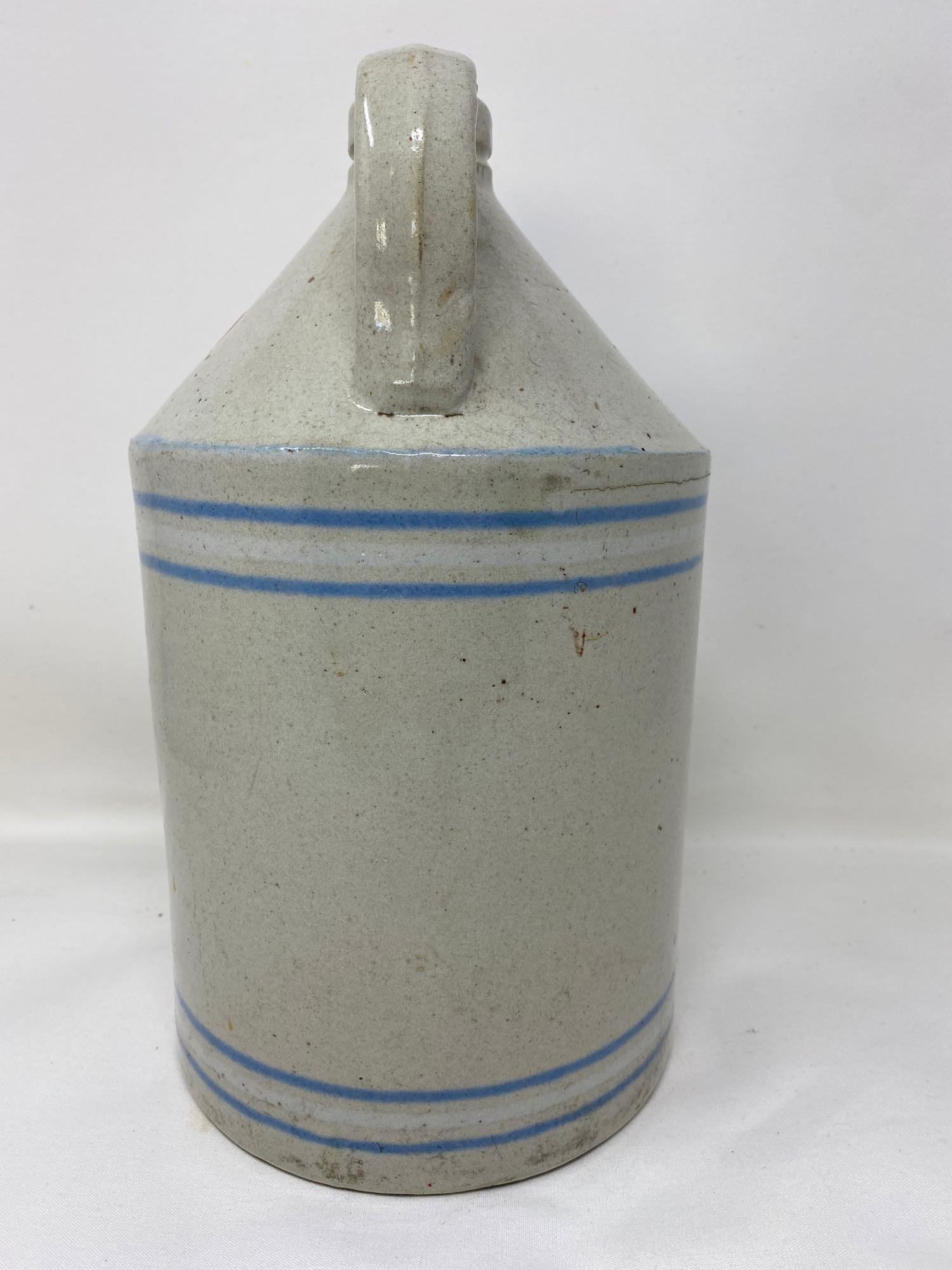 Antique white crock jug with blue and white lines