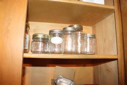 Contents of cabinet of ball and mason jars including measuring cups, etc.