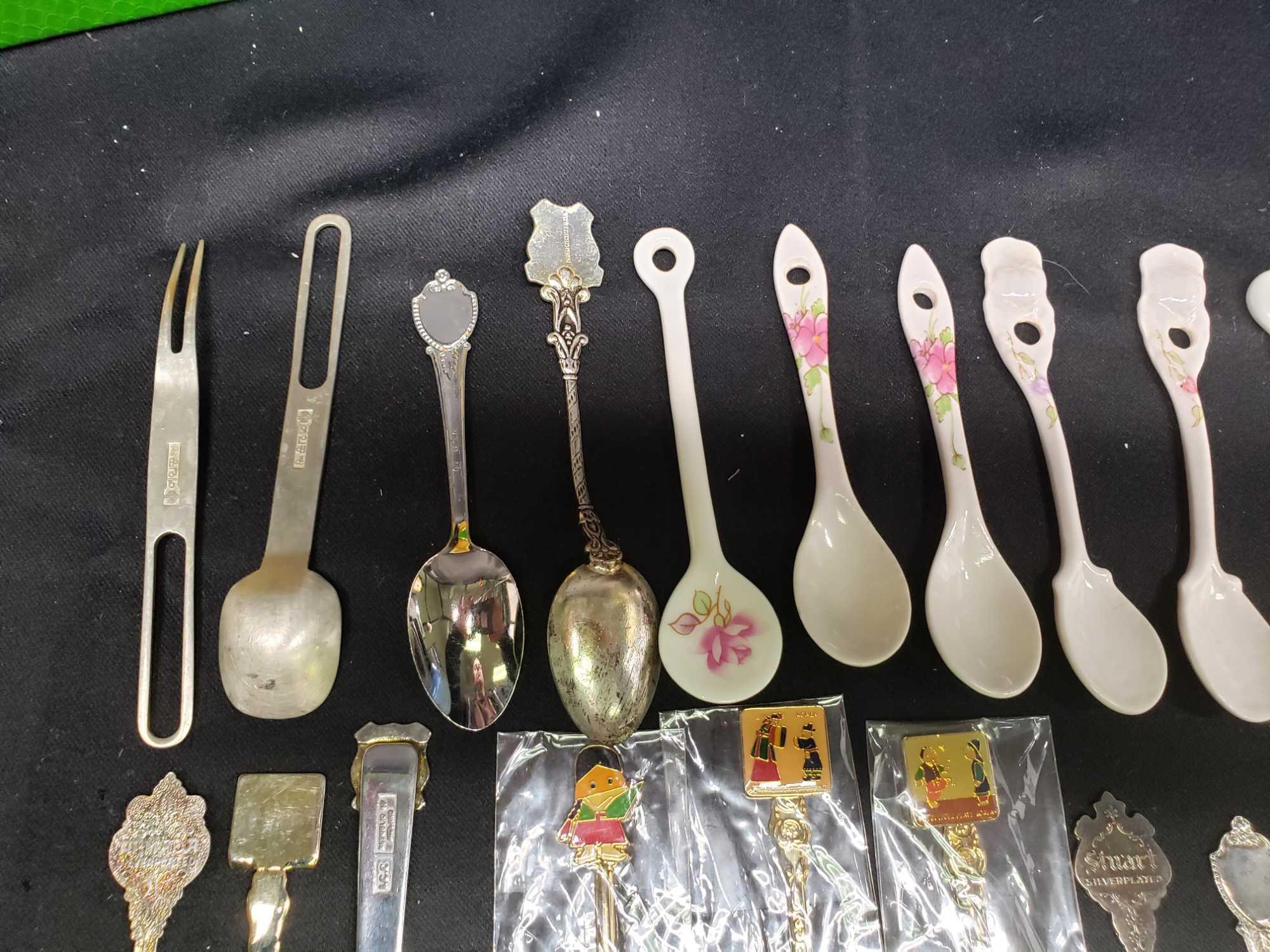 Collector spoons. Korea. Saipan. Canada. Silver and gold look. Some porcelain look spoons and fork.