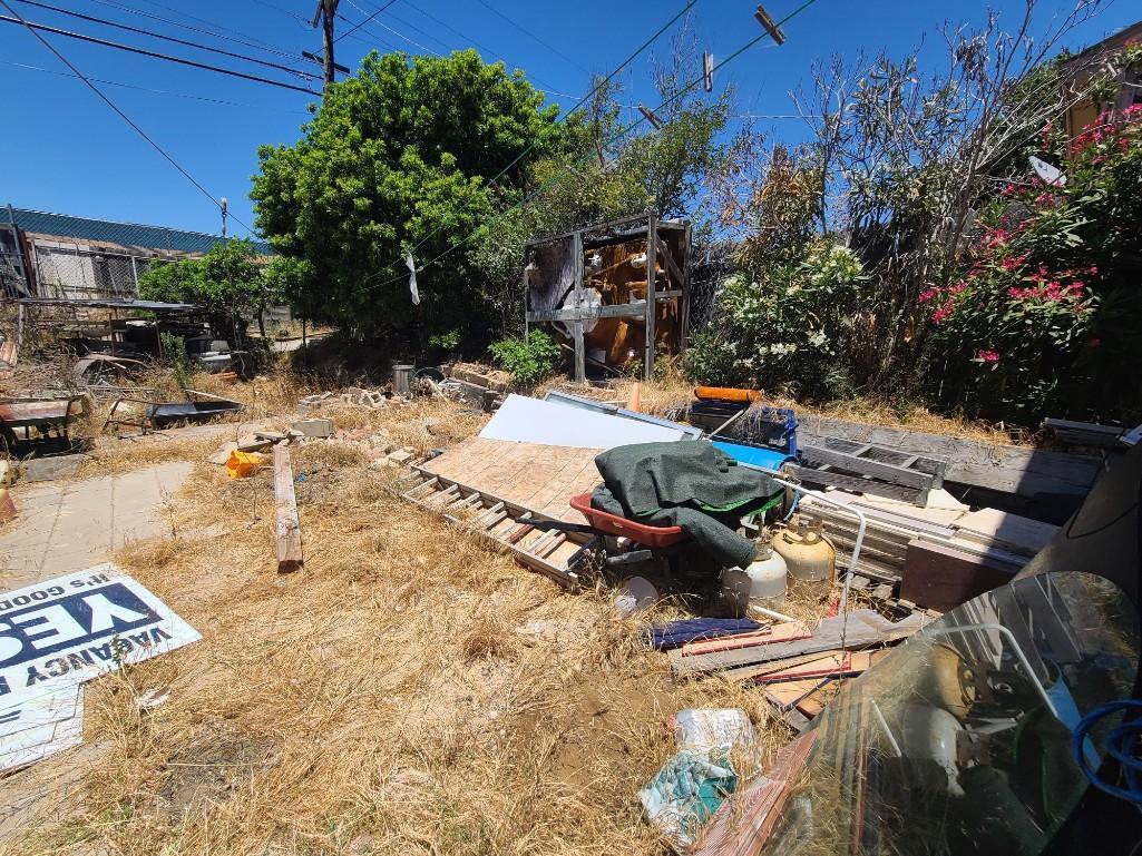 Backyard- Rusty Gold - Fencing lumber beams ladders trashcans rototiller pallet racking