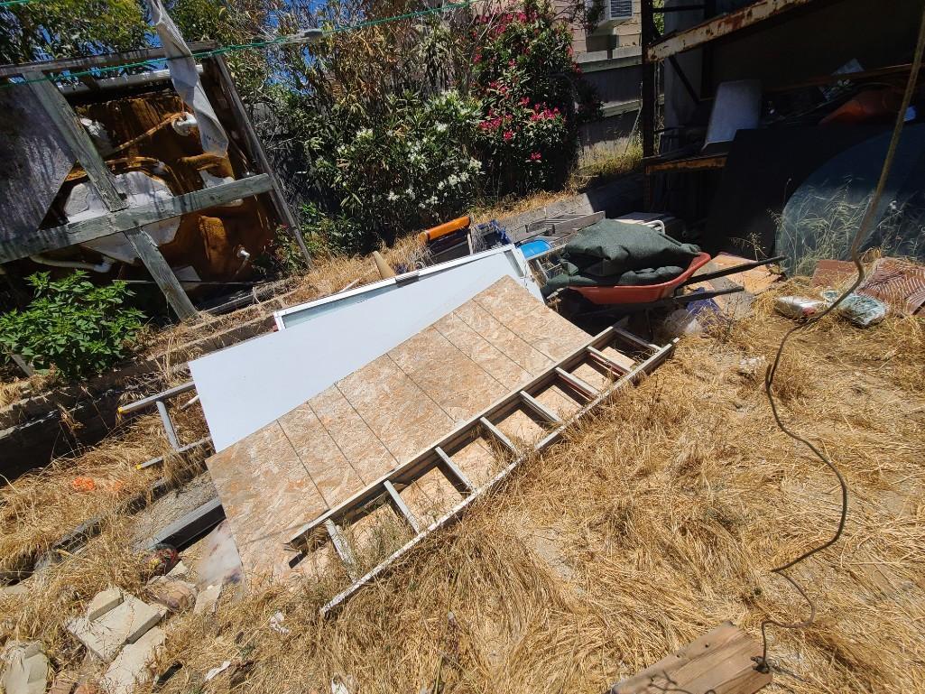 Backyard- Rusty Gold - Fencing lumber beams ladders trashcans rototiller pallet racking