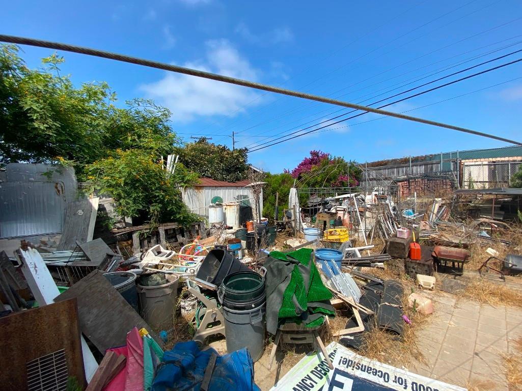 Backyard- Rusty Gold - Fencing lumber beams ladders trashcans rototiller pallet racking