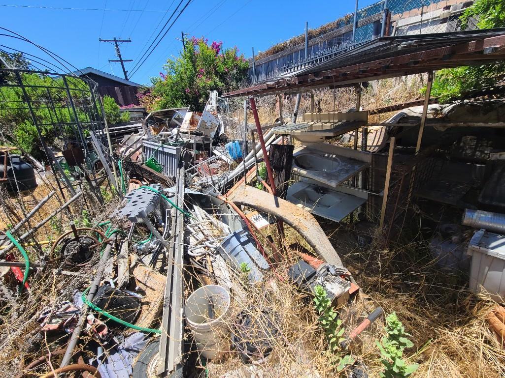 Backyard- Rusty Gold - Fencing lumber beams ladders trashcans rototiller pallet racking