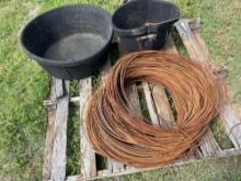 Feed bucket, mineral feeder, and a roll of heavy ga wire.