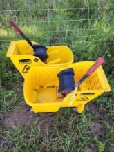 Two Rubbermaid yellow mop buckets with mop squeegee and one small dust mop Used.