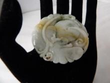 CARVED JADE MEDALLION IN LEAVES AND FORTUNE COIN MOTIF. APPROX 2" DIAMETER. GREEN AND BEIGE JADE.