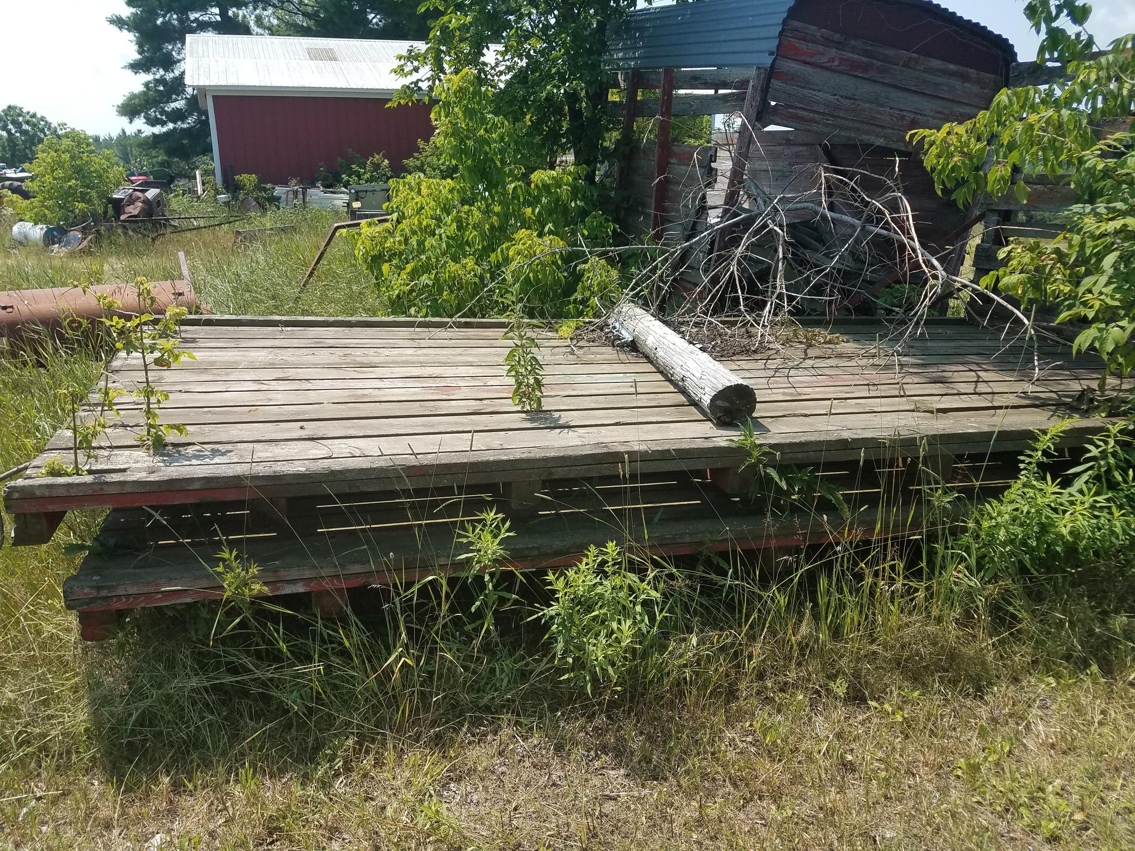 Large lot of misc equipment. Some for parts. 2 wooden fladbed hay racks. 84