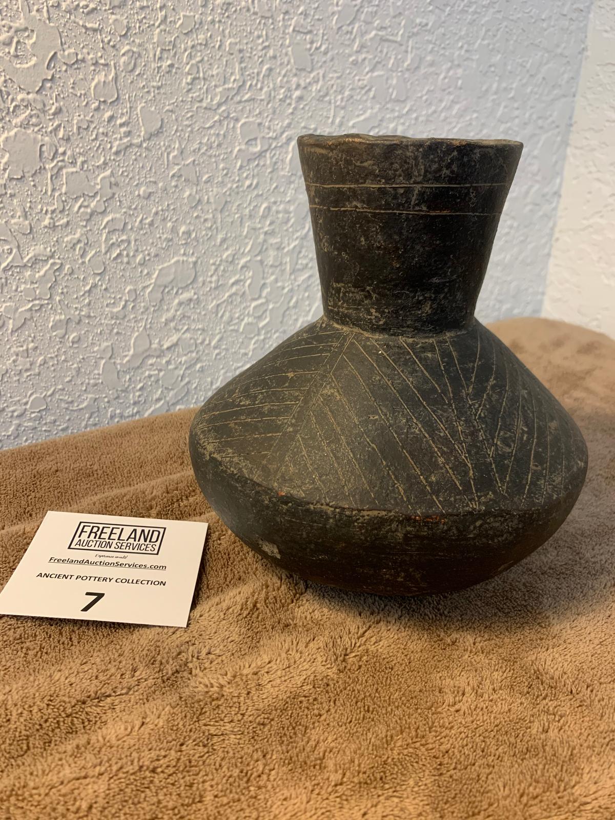 Black Pottery Vessel With Round Bottom And Decorative Sides