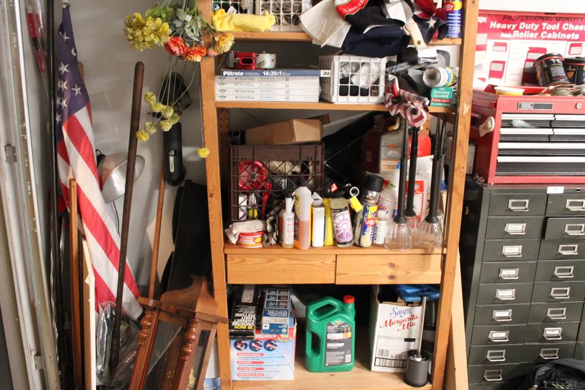 Shelf full of car care items, wood working kits, flags in the corner, the shelf and box’s of cedar w