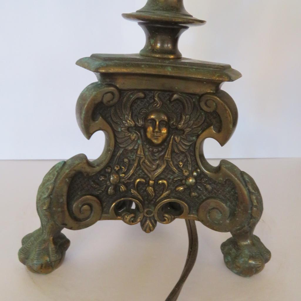 Ornate metal table lamp with faces and clawfeet