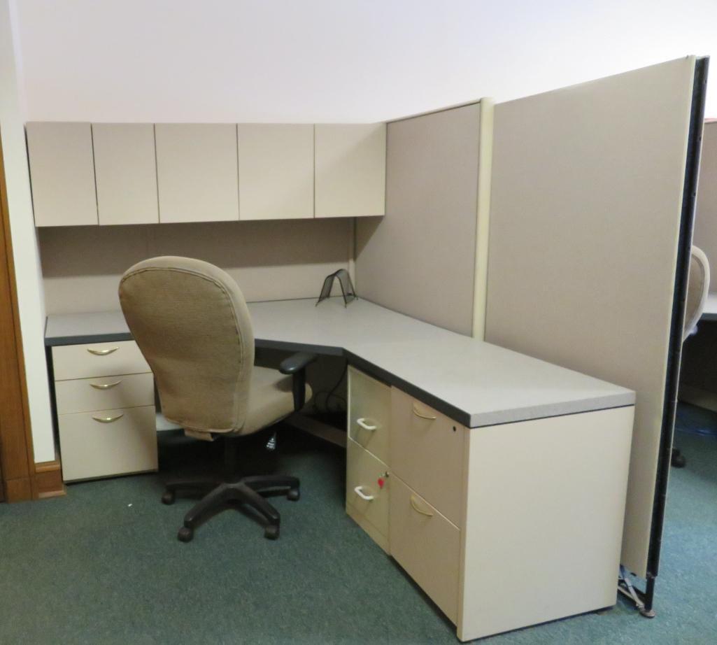 Office cubicle with files, chair, and upper cabinets and extra privacy wall