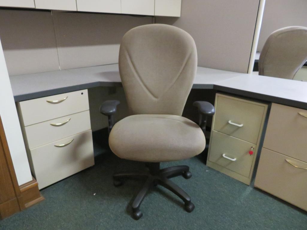 Office cubicle with files, chair, and upper cabinets and extra privacy wall