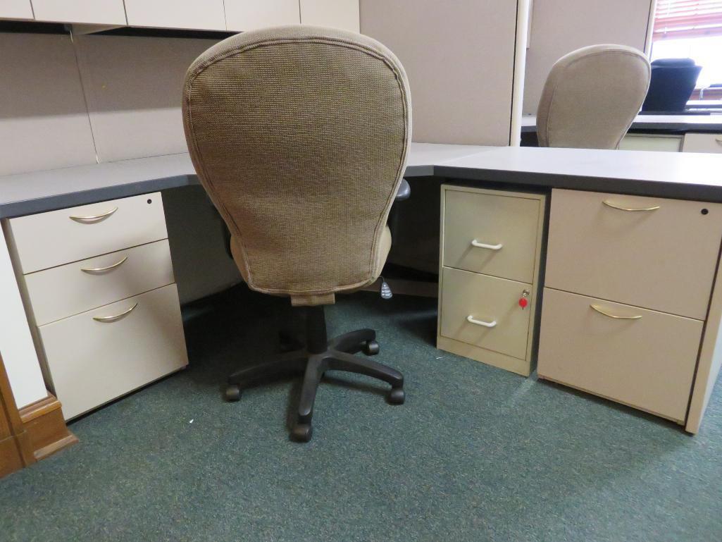 Office cubicle with files, chair, and upper cabinets and extra privacy wall