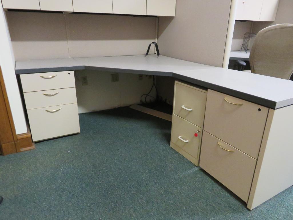 Office cubicle with files, chair, and upper cabinets and extra privacy wall